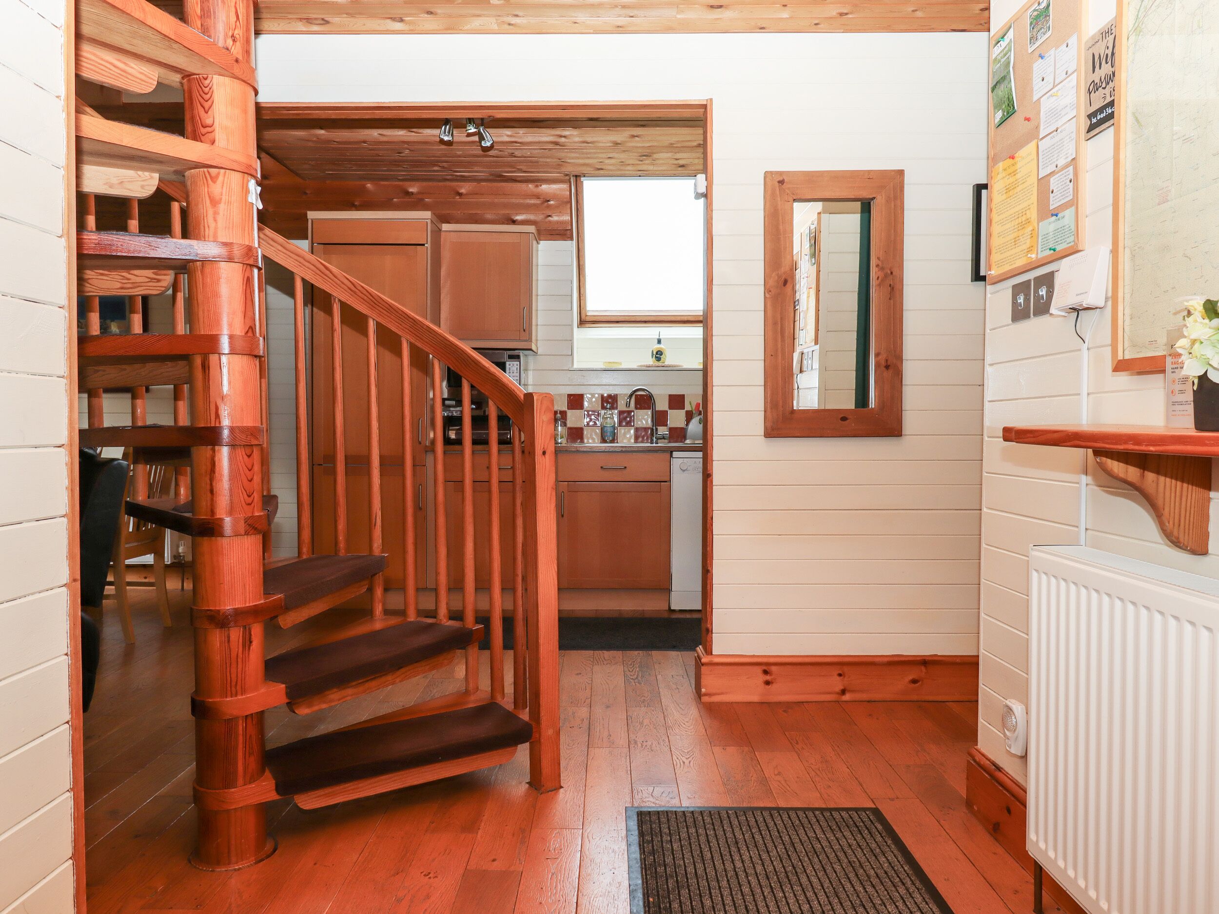 Una escalera de madera conduce a una cocina con vista al comedor.