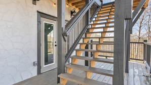 A wooden staircase with a metal railing leading to a deck. - Brand New Near PF~Royal Ridge~Indoor Pool-Racing Games (Sevierville)