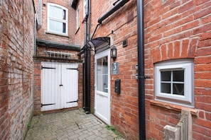 A narrow brick alleyway with a white door labeled 'Church Court' and a small window. - Boutique Apartment • City Centre • Free Parking • Fast WiFi • Self-Check-In • Yoko Property (Rugby)