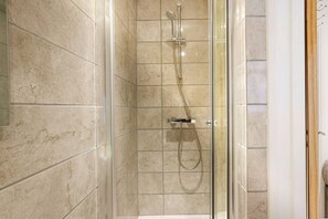 A glass-enclosed shower with a handheld showerhead and a fixed wall-mounted faucet. - Boutique Apartment • City Centre • Free Parking • Fast WiFi • Self-Check-In • Yoko Property (Rugby)