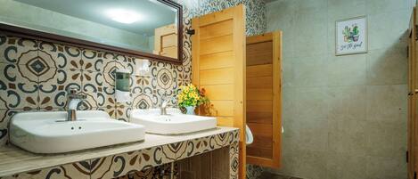 A bathroom with two sinks, a mirror, and a wooden door.