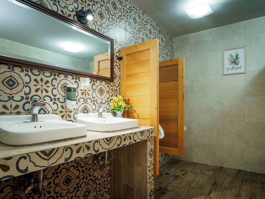 A bathroom with two sinks, a mirror, and a wooden door.