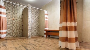 Ein Badezimmer mit gemusterten Fliesen, Holzboden und einer Bank.