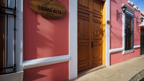 A building with a wooden door and a sign that reads "TIERRA ALTA SAN CRISTOBAL DE LAS CASAS". - Tierra Alta Hostal (San Cristóbal de las Casas)