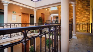 A spacious atrium with a high ceiling, a glass skylight, and a central staircase. - Tierra Alta Hostal (San Cristóbal de las Casas)