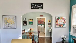A living room with a sofa, a dining table, and a kitchen in the background. - Upstairs @ Courthouse Square - Quirky (Hot Springs)