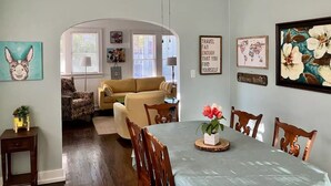 A dining area with a round table, wooden chairs, and a ceiling fan. - Upstairs @ Courthouse Square - Quirky (Hot Springs)