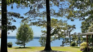 A serene lakeside view with a gazebo and trees.