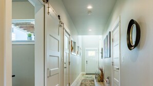 A hallway with wooden flooring, white doors, a sliding door, and a small rug. - Dog Friendly Townhouse, minutes to MSU & Downtown Bozeman! Welcome Home! (Bozeman)