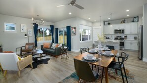A spacious living area with a dining table set for four, a kitchen with modern appliances, and a ceiling fan. - Dog Friendly Townhouse, minutes to MSU & Downtown Bozeman! Welcome Home! (Bozeman)