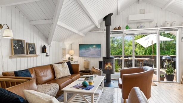 Una sala de estar acogedora con chimenea, sofás de cuero y un televisor grande.