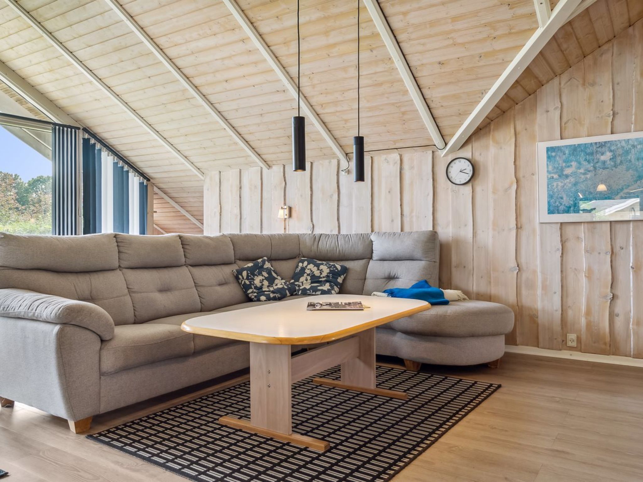 Een moderne woonkamer met een bank, een bijzettafeltje en een kamerkleed met dessin.