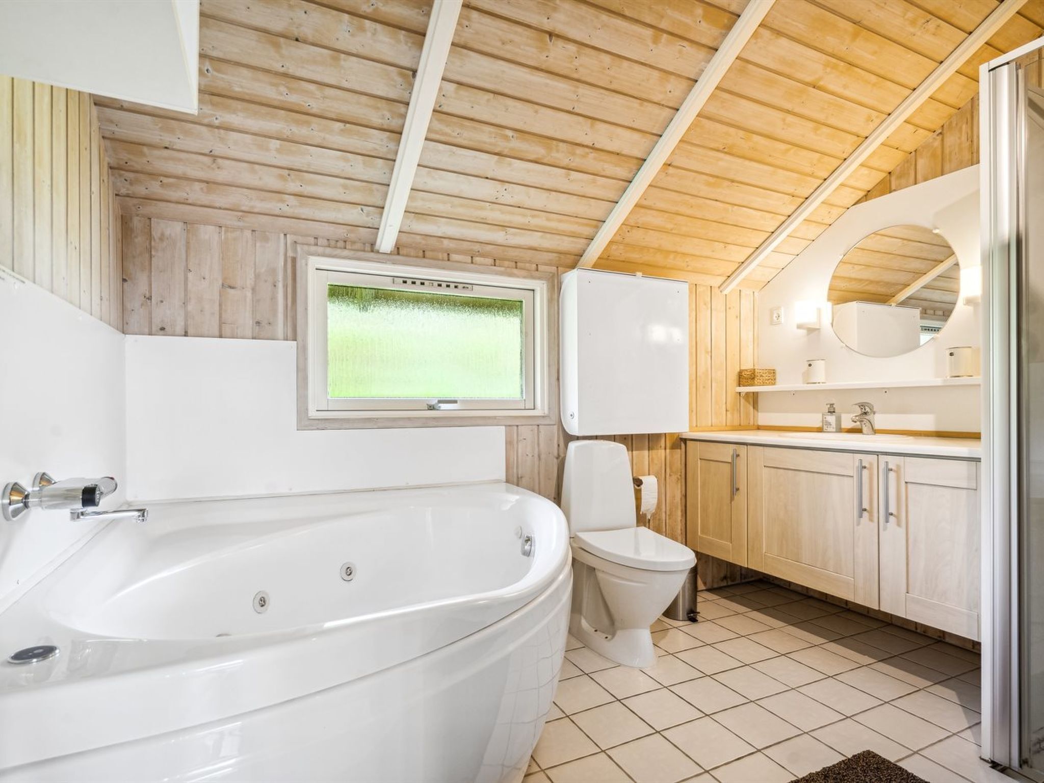 Une salle de bain moderne avec une baignoire sur pieds, des toilettes, un lavabo et un miroir.