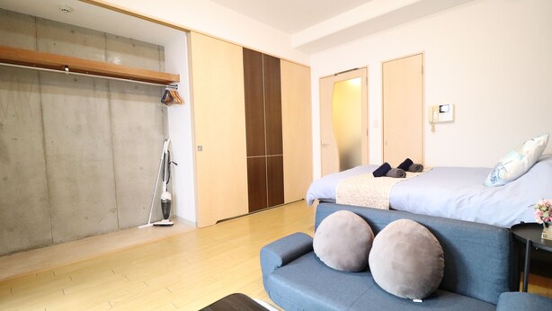 Una camera da letto moderna con un letto grande, un divano blu e un armadio.