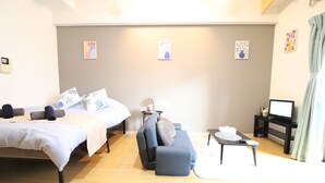 Una camera d'albergo con un letto, una poltrona, un tavolino e una televisione.