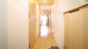 Un corridoio stretto con pavimento in legno e pareti color beige.