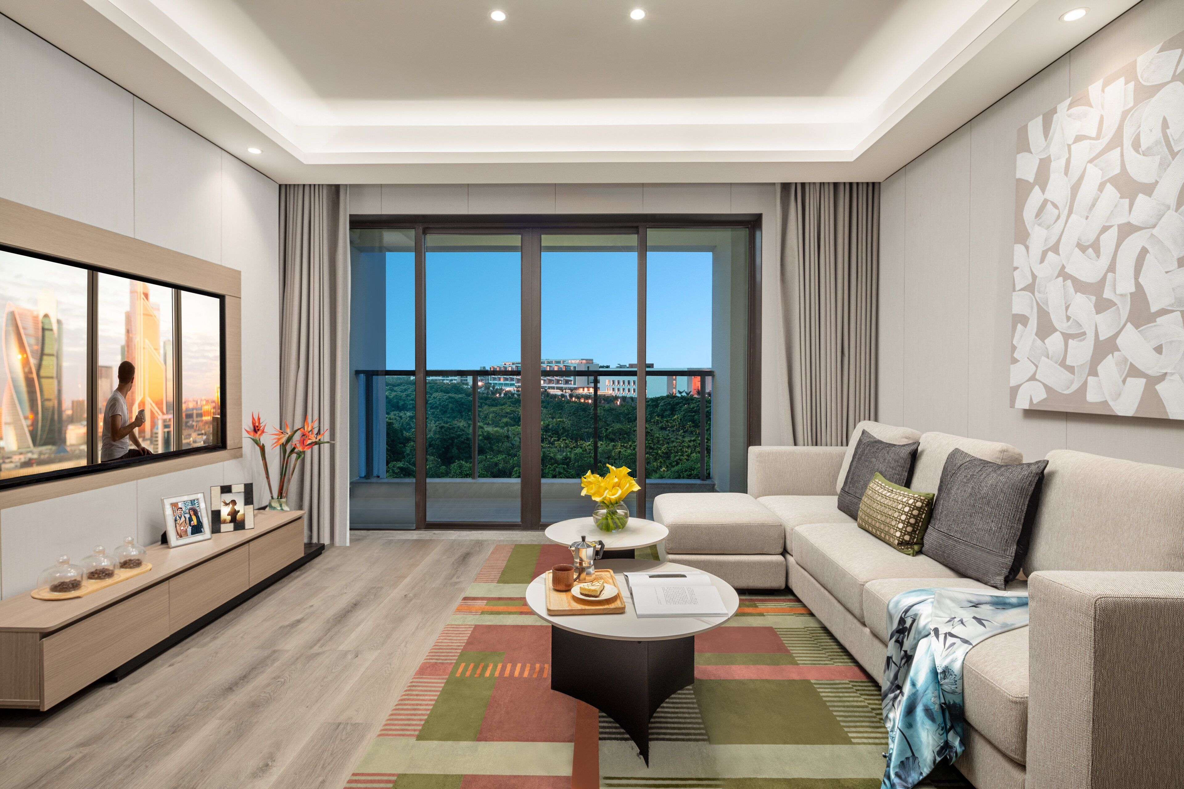 Una sala de estar moderna con un televisor grande, un sofá, una mesa de centro y vistas de la ciudad a través de amplios ventanales.