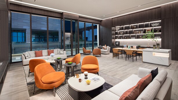 A modern hotel lobby with a seating area, a reception desk, and a large window offering a city view. - Citadines Hope City Boao (Qionghai)