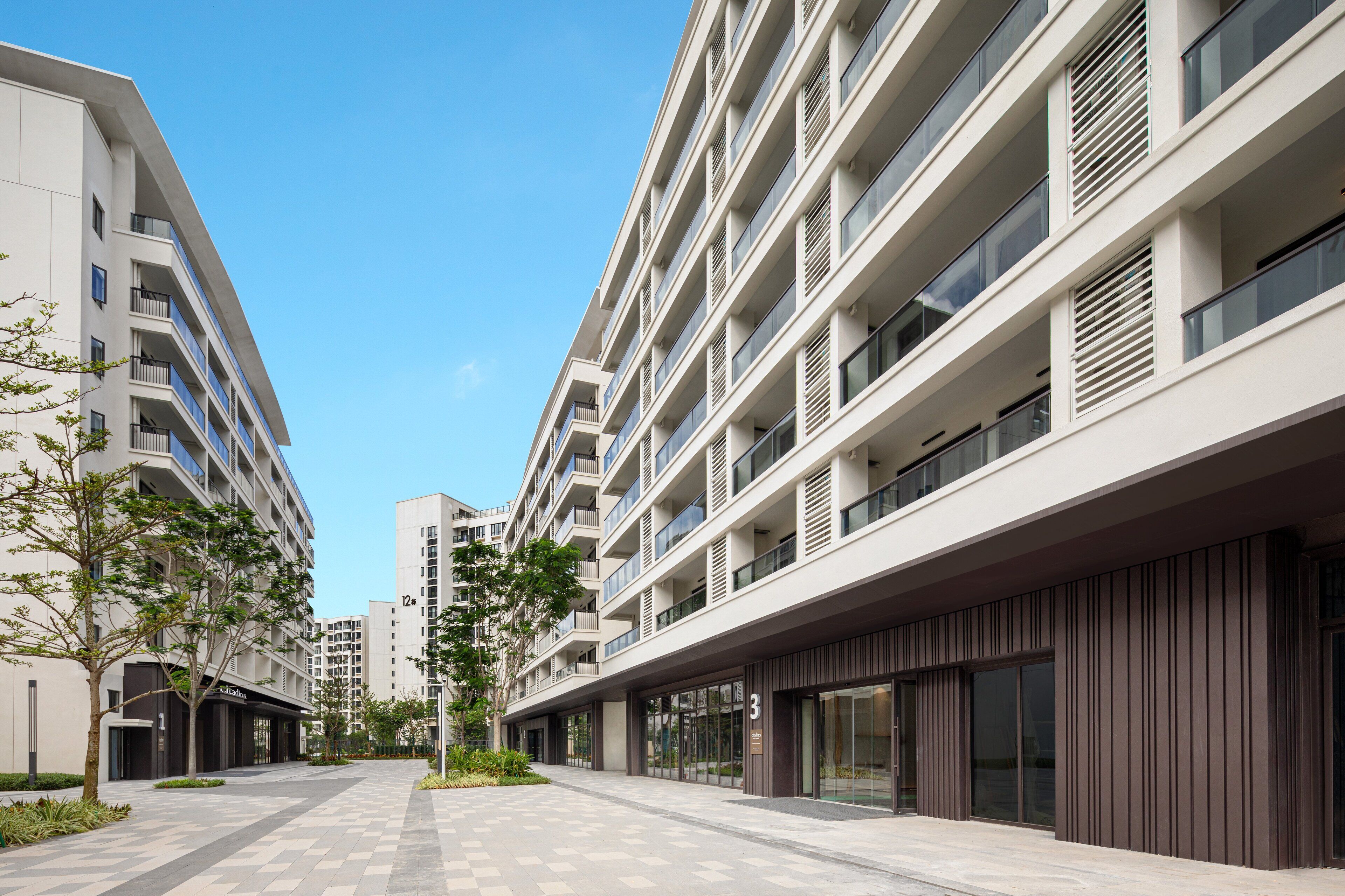 Un immeuble moderne à plusieurs étages, doté de balcons, de grandes fenêtres et d’un design épuré et géométrique.