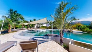 A pool area with lounge chairs and a shaded canopy. - Lion Fish Retreat (Placencia)