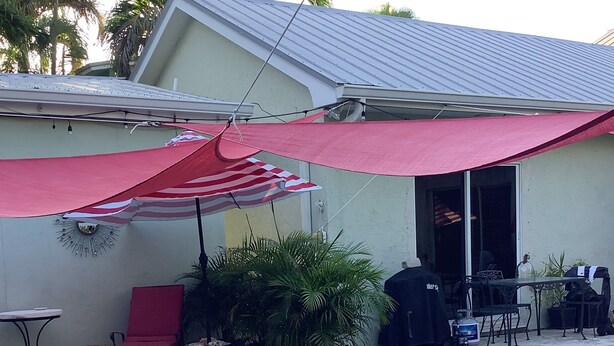 A swimming pool with inflatable toys, a red umbrella, and outdoor furniture. - Uptown quiet cottage close to beaches, restaurant & shopping.  (Key West)