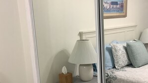 A bedroom with a bed, bedside table, lamp, and a framed picture on the wall. - Uptown quiet cottage close to beaches, restaurant & shopping.  (Key West)