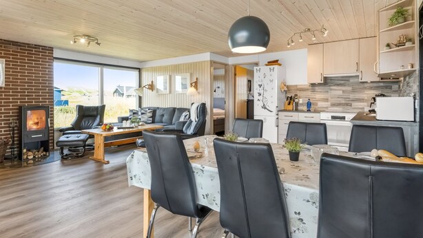 Un intérieur moderne comprenant un coin repas, une cuisine et une cheminée.