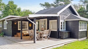 A cabin with a deck, a dining area, and a small porch.