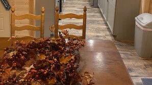 Una cocina moderna con armarios de madera, una mesa de comedor con un centro de mesa y una araña.