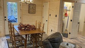 Una habitación acogedora con una mesa de comedor de madera, un sofá de cuero y una lámpara.