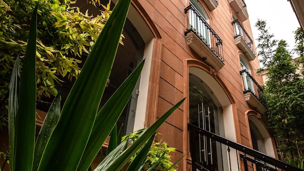 Um edif ício de vários andares com varandas, janelas amplas e estilo arquitetônico clássico.