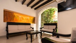 Uma sala de estar moderna com dois sofás, uma mesa de centro e um grande quadro abstrato na parede.