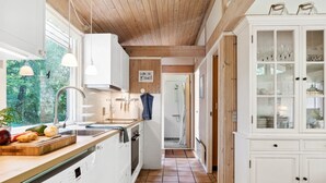 A kitchen with white cabinets, a wooden countertop, and a view of the outdoors. - "Judyta" - 250m to the fjord by Interhome (Nykøbing Sj)