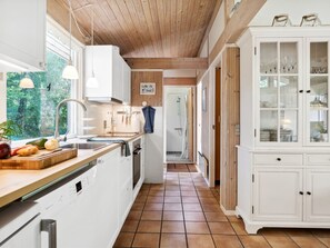 Kjøleskap, ovn, oppvaskmaskin og høy barnestol