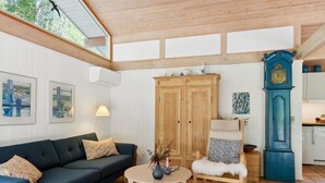 A living room with a dark sofa, a round coffee table, and a wooden cabinet. - "Judyta" - 250m to the fjord by Interhome (Nykøbing Sj)