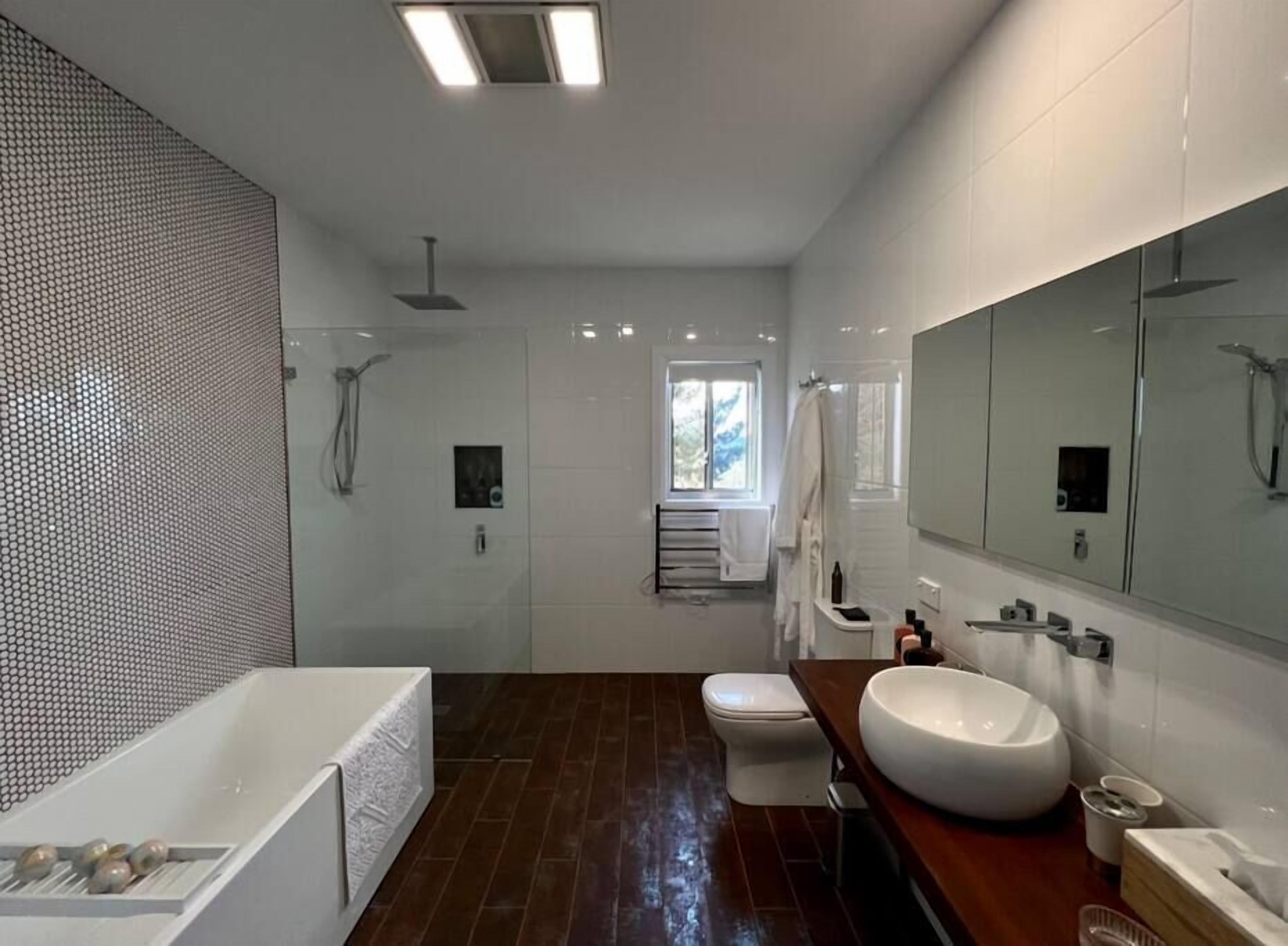 A modern bathroom with a bathtub, toilet, and sink.