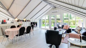 A spacious living area with a dining table and chairs, a sofa, and a coffee table. - "Arnsten" by Interhome (Ansager)