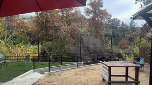 An outdoor seating area with a wooden deck, metal railing, and a sign for Budweiser World Center.