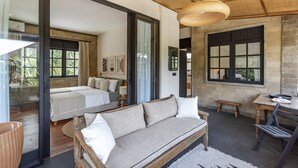 A modern bedroom with a large bed, a sofa, and a dining area with a table and chairs. - Exciting Chic 4BR Stylish Villa Next to Seminyak (Badung)