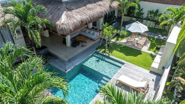 A poolside area with a thatched-roof structure, lounge chairs, and a well-maintained lawn. - Exciting Chic 4BR Stylish Villa Next to Seminyak (Badung)