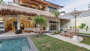 A modern house with a pool, outdoor seating, and a thatched roof. - Exciting Chic 4BR Stylish Villa Next to Seminyak (Badung)