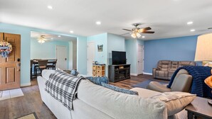 A living room with a sofa, a recliner, a TV, and a fireplace.