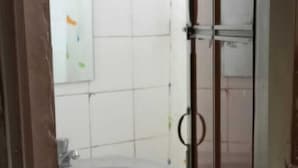 A bathroom with a pedestal sink, tiled walls, and a glass shower enclosure. - Cool Land Hot Hut (Nuwara Eliya)