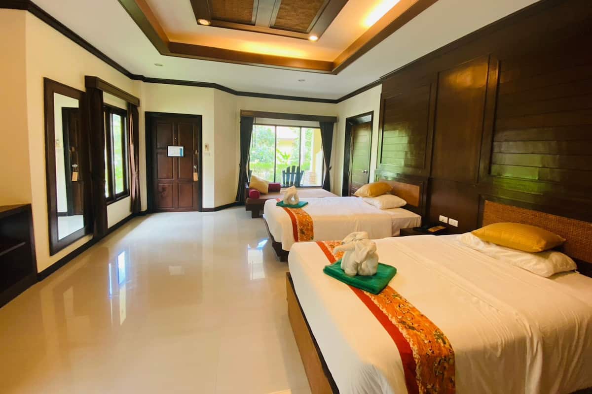 Une chambre d’hôtel avec deux lits, une grande fenêtre et un plafond orné d’un motif tissé.