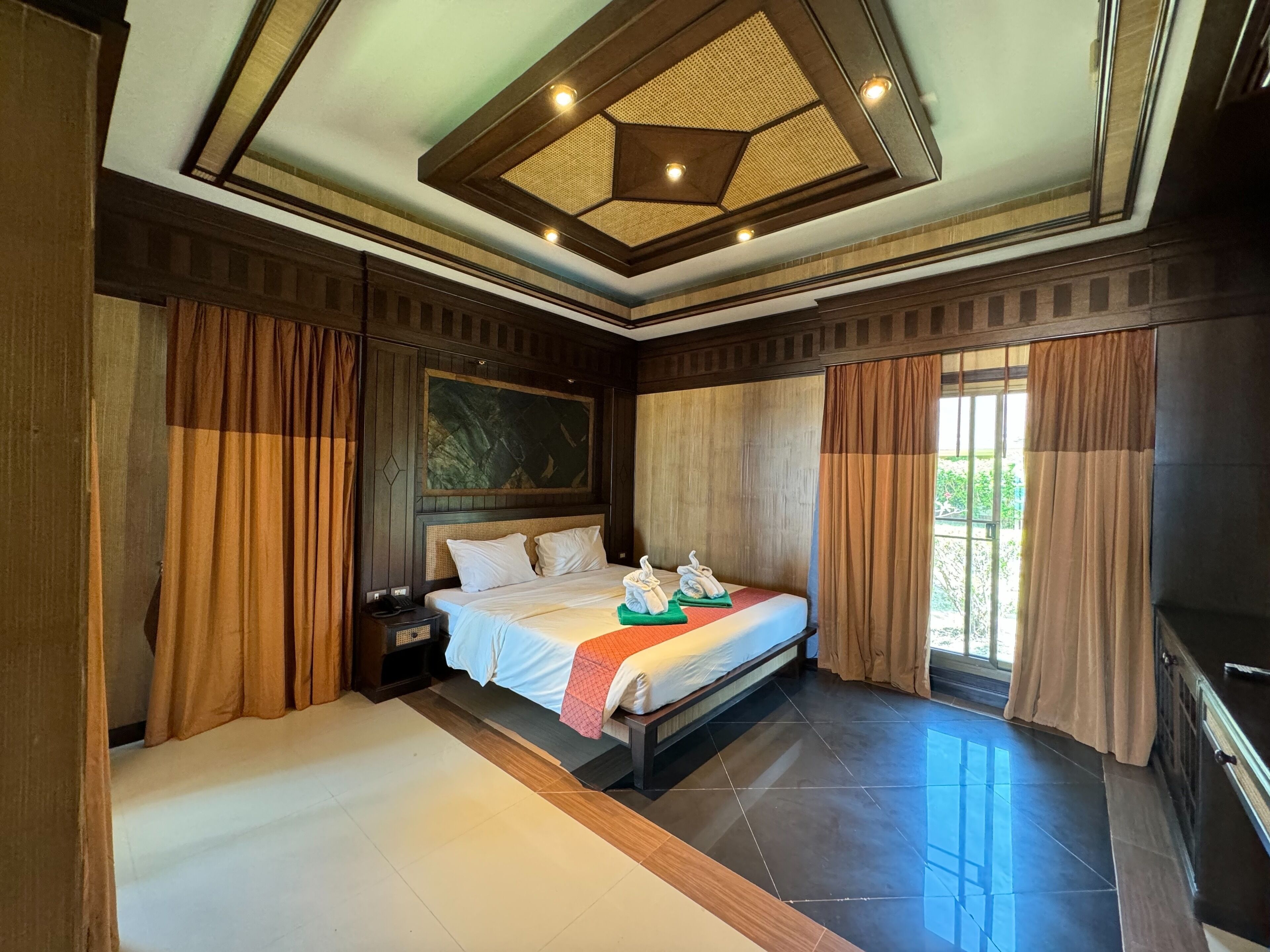A spacious bedroom with a large bed, a nightstand, and a TV.