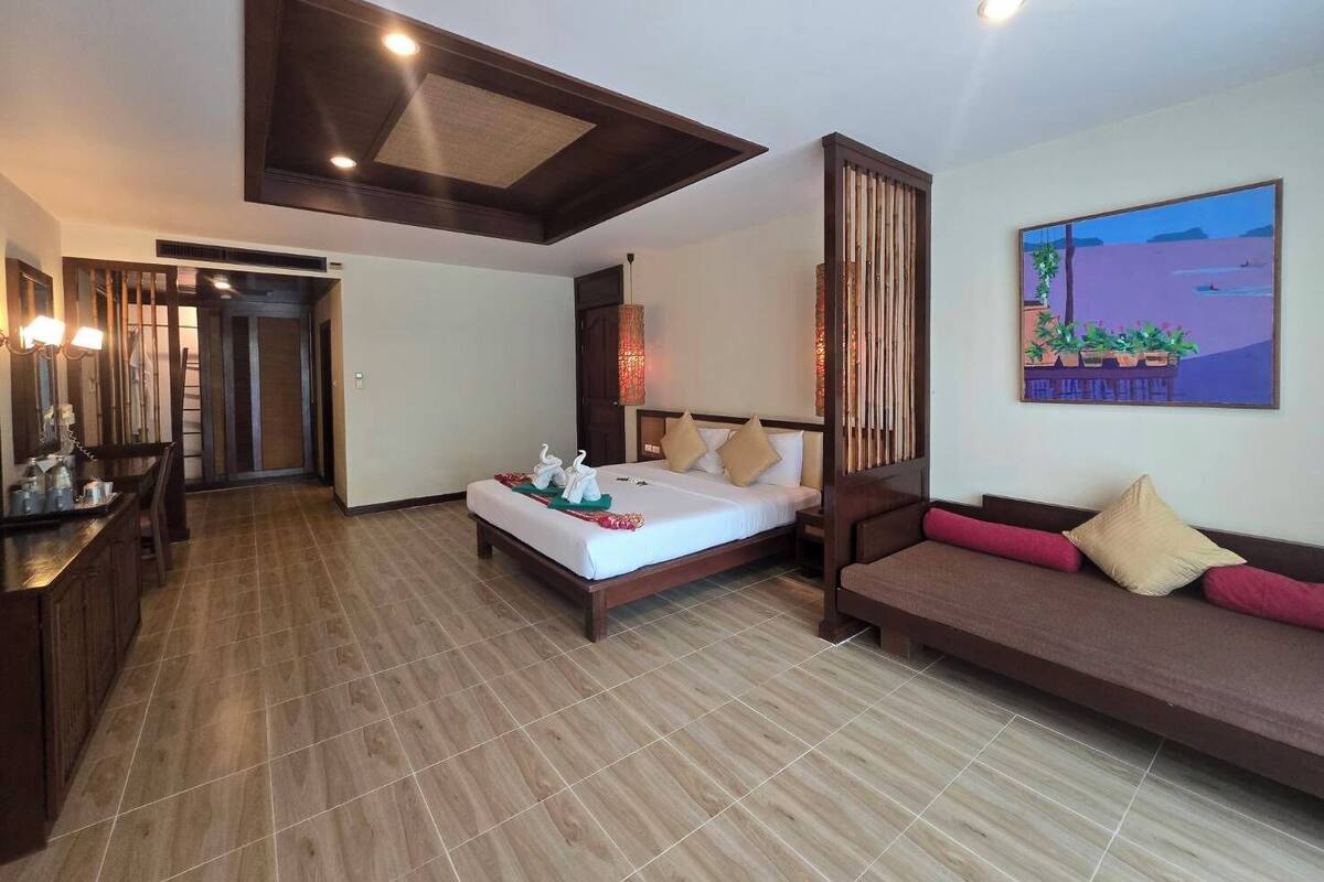 Une chambre d’hôtel avec un lit, un canapé, un bureau et un tableau au mur.