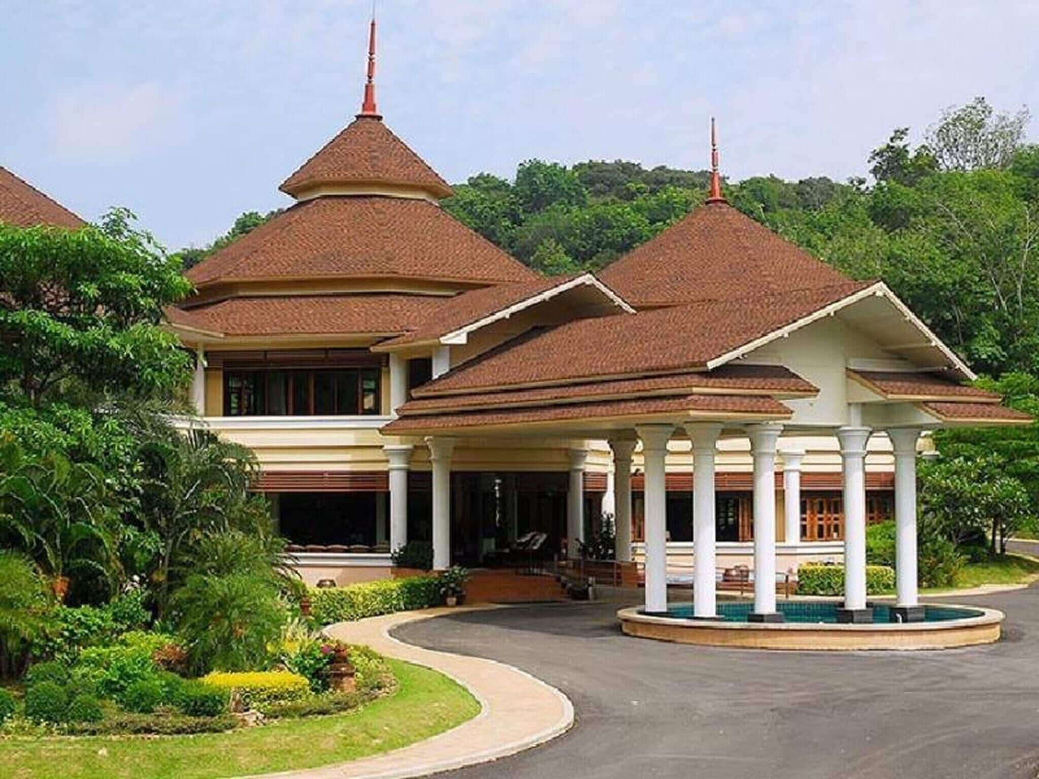 A large, multi-story building with a traditional architectural style, featuring multiple roofs and a central pavilion with columns.