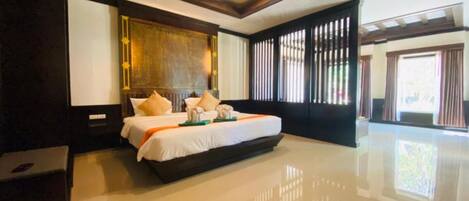 A spacious bedroom with a large bed, a wooden headboard, and a modern ceiling design.