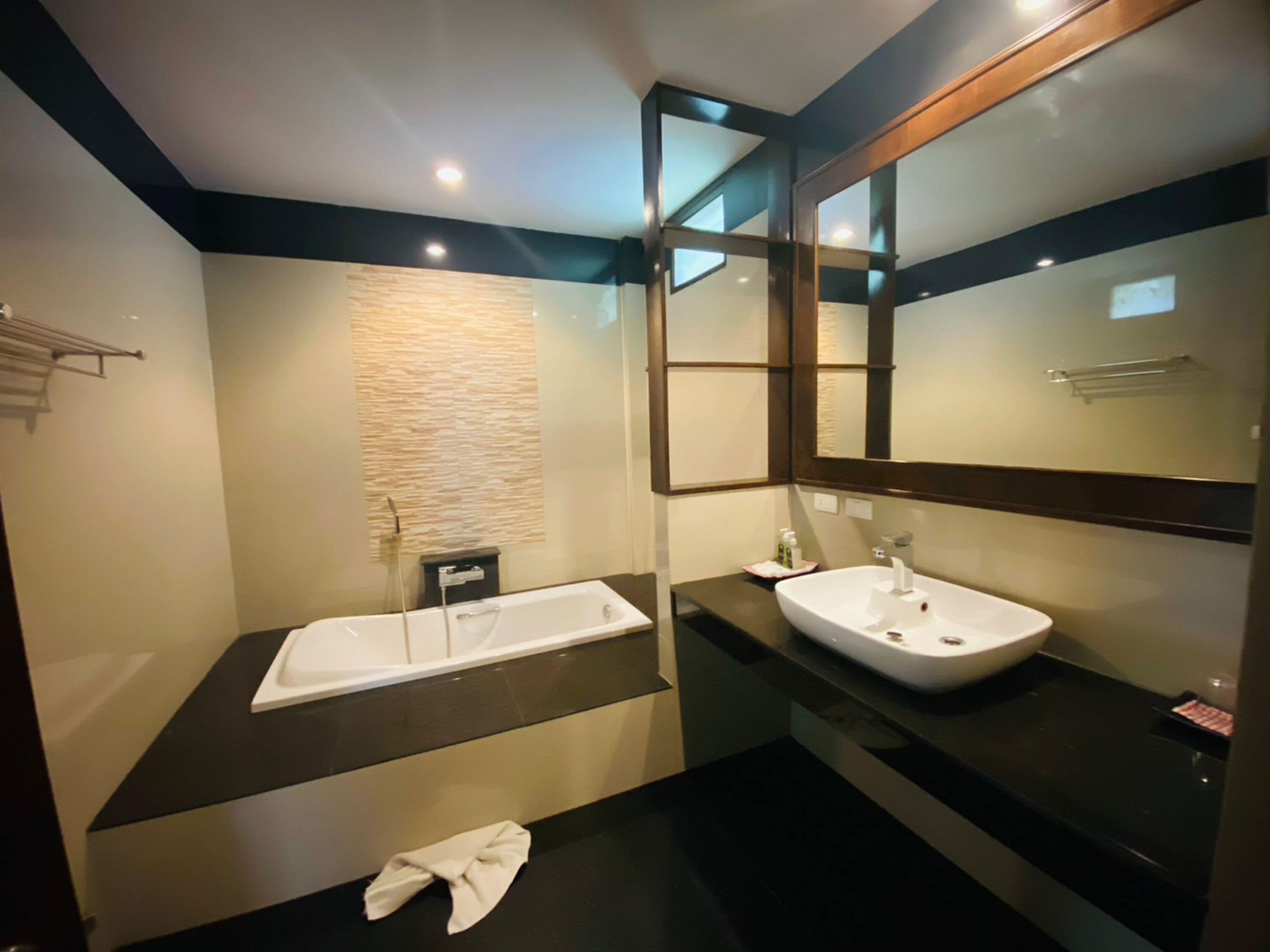 Ein modernes Badezimmer mit zwei Waschbecken, einem großen Spiegel und einem Handtuchhalter.