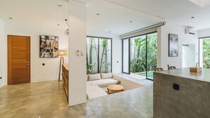 Ein modernes Interieur mit einer Holztür, einem Sofa, einem runden Tisch und einer Betonplatte.